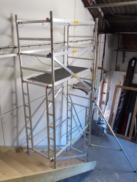 Narrow width stair scaffold tower featuring a walkthrough frame for clear staircase access